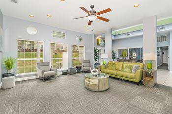A living room with a green couch and a ceiling fan.